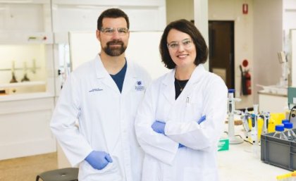 Two scientists in a lab wearing white lab coats 
